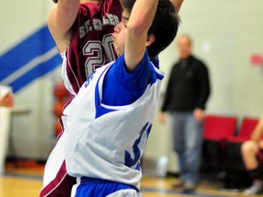 Jake Graham, left, of the St. Charles Cardinals, powers his way past Timmins High & Vocational School defender Billy Sutherland during the second half of Friday afternoon’s senior boys game at the 38th annual Lake Shore Gold Cup Classic Basketball Tournament. The Blues, defending champions in the senior boys division, jumped out to a 36-12 lead in the first half and cruised to a 66-25 victory over their Sudbury opponents.