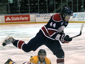 Sarnia Sting forward Charlie Sarault (in white) dives to knock the puck away from Gregg Sutch of the Saginaw Spirit Friday, Nov. 30, 2012 at the RBC Centre in Sarnia, Ont. (PAUL OWEN, The Observer)