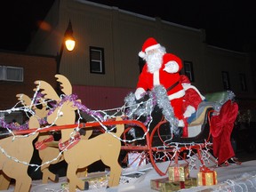 Santa Claus waves from his float Friday in the West Lorne Santa Claus parade. More than 25 floats and a marching band paraded through downtown.