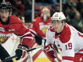 Owen Sound Attack Holden Cook (15) and Soo Greyhound Jared McCann (19) anticipate a play near Owen Sound goal crease.  The Hounds played against the Attack on  Saturday, Dec., 1, 2012., at the Essar Centre in Sault Ste. Marie, Ont., final score not yet available. RACHELE LABRECQUE - SAULT STAR/ QMI AGENCY