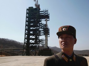A soldier stands guard in front of a rocket sitting on a launch pad at the West Sea Satellite Launch Site, during a guided media tour by North Korean authorities in the northwest of Pyongyang in this April 8, 2012 file photo. North Korea will launch a satellite in mid-December, the official KCNA news agency quoted officials as saying on December 1, 2012. The satellite would be launched between December 10-22, it quoted a spokesman for the Korean Committee for Space Technology as saying. (REUTERS/Bobby Yip/Files)