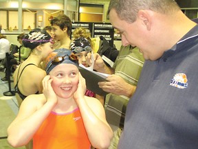 Cornwall coach Simon St-Pierre chats with swimmer Mackenzie Wright in a noisy Aquatic Centre.