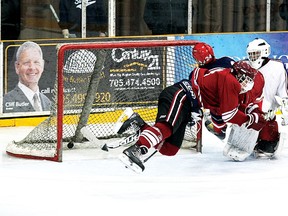 Tyler Dominelli of the St. Charles Cardinalsgoes airborne after taking a hit from Widdifield’s Ryley Valade to score a goal during the Cardinals’ 4-1 win in the NDA tournament final at Memorial Gardens, Sunday. (Ken Pagan, The Nugget)