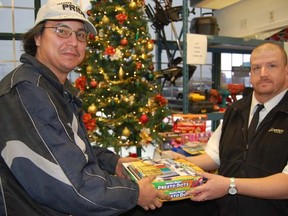 Lawrence Dashner hands over a toy donation to the Salvation Army's Peter Lewis at the Hock Shop on Saturday. Jonathan Migneault The Sudbury Star