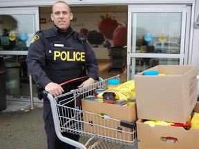 OPP Const. Rob St. Marseille with a grocery cart full of donated food items. Jonathan Migneault The Sudbury Star