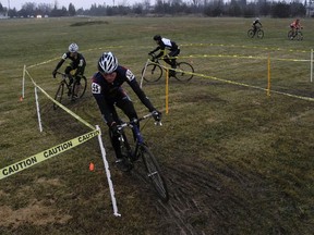 Racers in the men's race ride across the driving range at the Westbrook Golf Club during Sunday's cyclocross race. (Elliot Ferguson/The Whig-Standard)