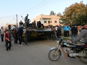 Free Syrian Army fighters and residents gather near a tank, which they say was captured from the Syrian army loyal to President Bashar al-Assad, after clashes in Houla near Homs, December 2, 2012. REUTERS/Misra Al-Misri/Shaam News Network/Handout