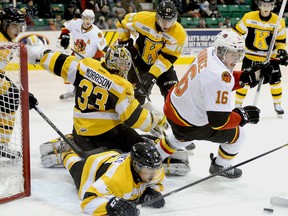 Belleville's Brendan Gaunce eyes a loose puck after colliding with Frontenacs goalie Mike Morrison on Saturday night at Belleville's Yardman Arena. Morrison made 42 saves to preserve a 3-1 victory over the Bulls.