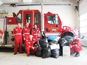 Members of the Whitecourt Fire Department pose the all the donations of cold weather clothing they received on the weekend of Nov. 30 when firefighter Mike Minderlein camped on the roof of the fire station for three days.
Barry Kerton | Whitecourt Star