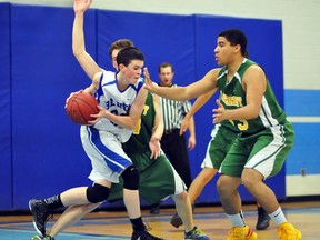 Matti Kohtala, of the Timmins High & Vocational School Blues, attempts to drive the ball past Lockerby Vikings defenders Spencer Pierce, left and Triston Simeoni during the championship game in the junior division at the 38th annual Lake Shore Gold Cup Classic Basketball Tournament at TH&VS on Saturday. The Vikings scored a 54-52 win over the host Blues to claim the championship.