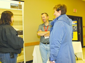 Malcolm Mayes, Shell’s general manager of in situ operations, talks with Stacy Mikolajcyzk (left) and Cathy DeDecker at the Nov. 28 open house.