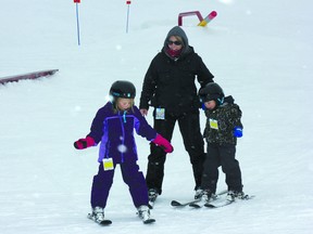 Taylor, Michelle and Carter Wicklund come off the hill after skiing on the seasonal opening day at Kinosoo Ridge Snow Resort.