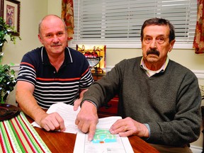 Church Street residents Jim Barbour, left, and Joe Dionne point to a petition they have circulated objecting to the opening of the west end of their street as an access point to a new west-end subdivision. RONALD ZAJAC The Recorder and Times