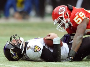 Baltimore Ravens quarterback Joe Flacco (L) lies on the turf after being sacked by Kansas City Chiefs linebacker Jovan Belcher during the first half of their AFC Wild Card NFL playoff football game in Kansas City, Missouri January 9, 2011. (REUTERS/Dave Kaup)