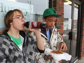 SCITS students Josh Somes, left, and Austin Wright have lunch outside 5 Corners Coffee & Subs in Mitton Village in Sarnia, Ont. Monday, Dec. 3, 2012. They say more SCITS students are flocking to restaurants and variety stores after Ontario introduced its school junk food ban over a year ago. (BARBARA SIMPSON, The Observer)