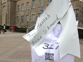 White ribbons bearing two names — one the name of a victim of the 1989 Montreal Massacre, the other the victim of gender-based crime since then - hang from the emergency blue light poles across the Queen's University campus in advance of Thursday's anniversary memorial. (Michael Lea/The Whig-Standard)