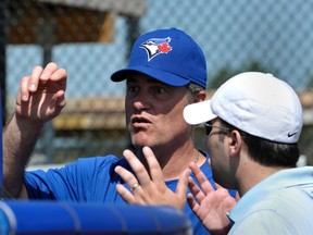 Ex-Blue Jays manager John Farrell talks with general manager Alex Anthopoulos during spring training last year. Even with Farrell gone, the two remain friends. (REUTERS)
