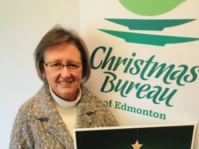Christmas Bureau executive director Wendy Batty poses with a picture of the non-profit charity’s new logo. TREVOR ROBB Edmonton Examiner