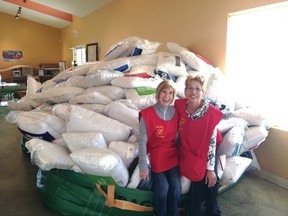 Airdrie Lioness Club members Debbie White and Betty McNicol stand in front of some of the nearly 500 pillows collected from Airdrie Minor Hockey Association games on the weekend.