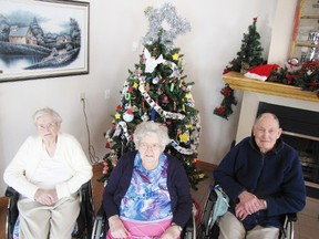 Extendicare Mayerthorpe residents, from left, Myrtle Johnston, Lucy Shirley and Howard Sharp pose on Wednesday, Dec. 5, with the Christmas tree for which they made all the decorations (behind them) which is set up in the foyer.