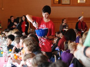 Grande Prairie Comp student Tyler Poitras dishes out meals to Avondale students at the Elks Hall during the school’s annual turkey luncheon Wednesday. Comp students helped to serve the food that was paid for by Avondale and prepared by Elks volunteers.
ADAM JACKSON/DAILY HERALD-TRIBUNE/QMI AGENCY