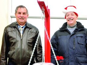 Tim Blake, left, and John Thompson switch places behind the Salvation Army kettle at the LCBO location on Parkedale Avenue on Wednesday. Every volunteer does a two-hour shift on the kettle. DARCY CHEEK The Recorder and Times