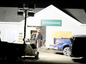 Workers tend to the hole in the wall created after a vehicle crashed into the front entrance of the Kincardine Service Ontario office Monday afternoon. (TROY PATTERSON/KINCARDINE NEWS)