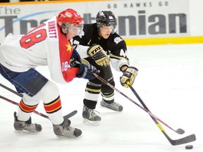 Trenton Golden Hawks' Alex leader and Wellington Dukes' Brian Bunnett battle for the puck during the Hawks' 3-1 win Friday at the Community Gardens.