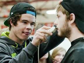 Jesse MacIntyre shaves the face of Brett Johnston. MacIntyre and his team outbid the gym full of students to have the first choice over whose face to shave.