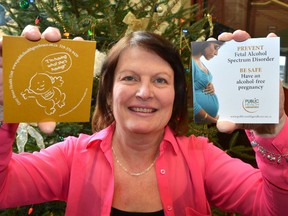 Public health nurse Marilyn Lemon with coasters advising pregnant women not to drink.