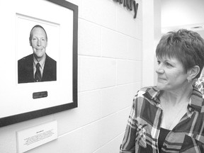 Catherine Merritt, partner of the late Albert Riddell, examines his picture on the Timken Arena Wall of Fame Thursday during its unveiling. Merritt nominated Riddell who is the first person to be inducted on to the Wall of Fame. (Nick Lypaczewski, Times-Journal)