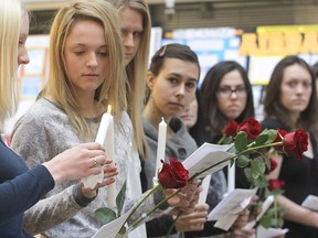 Fourteen roses and candles, held by Queen's University students during an Engineering Society memorial service Thursday afternoon, symbolized the 14 women killed at L'Ecole Polytechnique in 1989. (Michael Lea/The Whig-Standard)