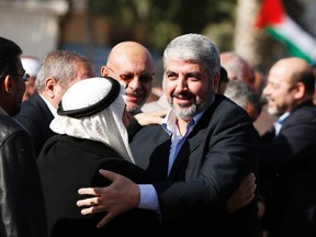 A Palestinian man hugs Hamas chief Khaled Meshaal (R) upon his arrival at Rafah crossing in the southern Gaza Strip on December 7, 2012. (REUTERS/Suhaib Salem)