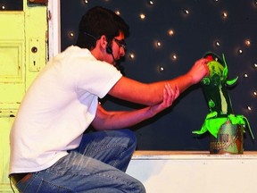 Grade 11 student Nabil Ibrahimi, who stars as Seymour Krelborn, gives Audrey II a drop of blood, in the Wetaskiwin Composite High School's drama department production of the musical Little Shop of Horrors, which runs this week.