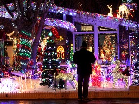 A visitor takes in the light display at Maisie's Magical Christmas House, at the corner of 97 Street and 144 Avenue, Sunday Nov. 18, 2012. Send us your Christmas pics below! (DAVID BLOOM/EDMONTON SUN)