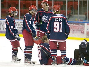 Teammates gather around fallen defenceman Sheehan Kirkwood, who suffered what is believed to be a broken ankle.