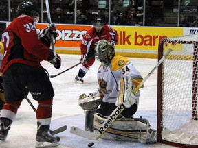 Sarnia Sting goaltender J.P. Anderson makes a pad save on Emerson Clark of the Windsor Spitfires, left, in the second period Friday, Dec.7, 2012 at the RBC Centre in Sarnia, Ont. (PAUL OWEN, The Observer)