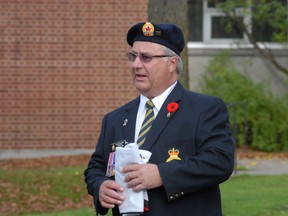 Wayne Paulencu, poppy campaign chair for Royal Canadian Legion Branch 25, holds the campaign's flag at a kickoff event at Sault Ste. Marie's cenotaph in October 2011.