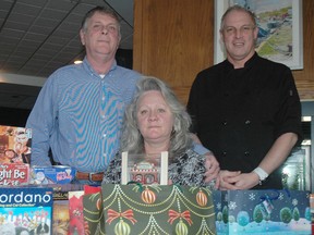 Port Stanley's The Wharf owners Gary, left, and Barb Scrivens and Wharf chef John Boerkamp with a few of the presents the restaurant will distribute as part of its annual Christmas dinner for community members who otherwise would have to celebrate alone. Reservations for the Christmas day meal can be made by calling the restaurant at 519-782-7788. (Nick Lypaczewski, Times-Journal)