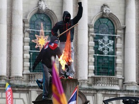 Protesters burn the Irish national flag in front of Belfast's City Hall December 8, 2012. (REUTERS/Cathal McNaughton)