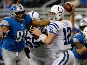 Indianapolis Colts quarterback Andrew Luck, right, is pressured by Detroit Lions defensive tackle Ndamukong Suh during the first half of their NFL football game in Detroit, Michigan December 2, 2012.  REUTERS/Rebecca Cook