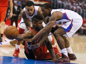 The Raptors' Amir Johnson is pressured by Los Angeles Clippers' Matt Barnes (left) and Eric Bledsoe on Sunday afternoon at the Staple Center. (Reuters)