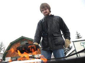 John Harper roasts chestnuts on an open fire during the Old Fashion Christmas at the Grande Prairie museum on Sunday. The annual event included cookie decorating, carollers, a visit from Santa and sleigh rides on a horse-drawn carriage. (Graeme Bruce/Daily Herald-Tribune)