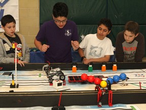 Members of the First Lego League team from St. Thomas More Catholic School watch as their robot attempts to cross the balancing bridge on this year's field, while practising before the First Lego League Eastern Ontario Provincial Qualifiers on Sunday. (Tori Stafford The Whig-Standard)