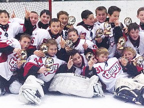 The Quinte Red Devils minor peewees celebrate their Quinte Cup victory at the Sports Centre last weekend. (Photo submitted.)