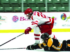 Midget Thistles forward Evan Mignault leans around a Brandon Wheat Kings defender in Kenora’s 3-2 shoot-out loss Sunday.
GARETT WILLIAMS/Daily Miner and News