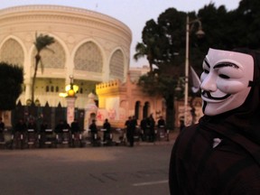 An Anti-Mursi protester, wearing a Guy Fawkes mask, stands in front of the presidential palace in Cairo December 10, 2012. REUTERS/Mohamed Abd El Ghany