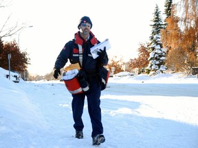 Dion Burry, letter carrier for Canada Post, delivers mail near Poplar Drive and 78 Avenue Monday afternoon. With Christmas quickly approaching, Canada Post expects Dec.13 to be their busiest day of the year. PATRICK CALLAN/DAILY HERALD-TRIBUNE
