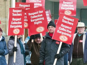 Barb Allen, Doug Yeo, and Dennis Watts show protest Bill 115 outside Lisa Thompson’s Blyth office on Dec. 10.