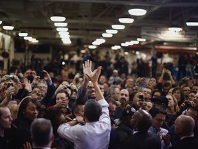 U.S. President Barack Obama high-fives an employee of the Daimler Detroit Diesel plant following remarks and a tour in Redford, Michigan, December 10, 2012.  Obama travelled to Michigan for an event on the economy.   REUTERS/Jason Reed